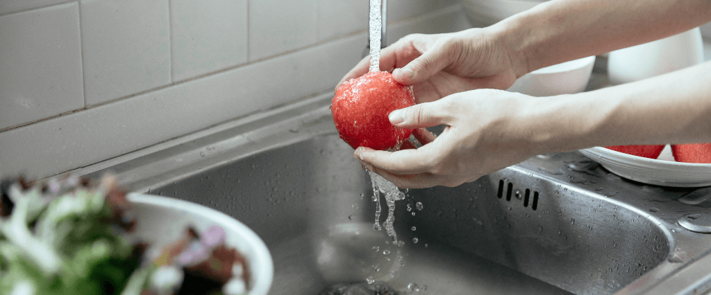 washing an apple at the kitchen sink
